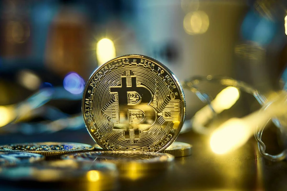 Złote bitcoiny na ciemnej, lustrzanej powierzchni