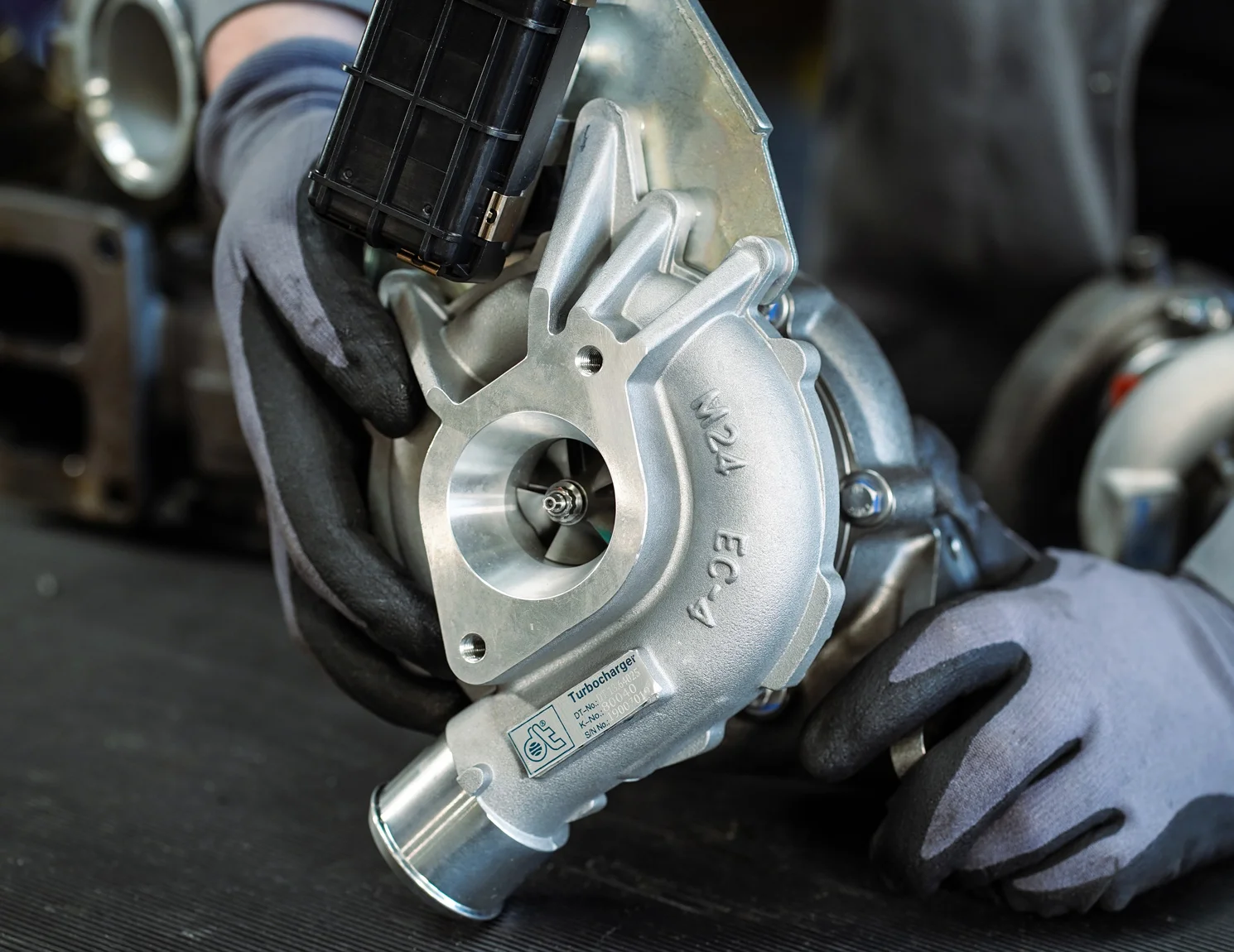 Elementy turbosprężarki ułożone na stanowisku roboczym