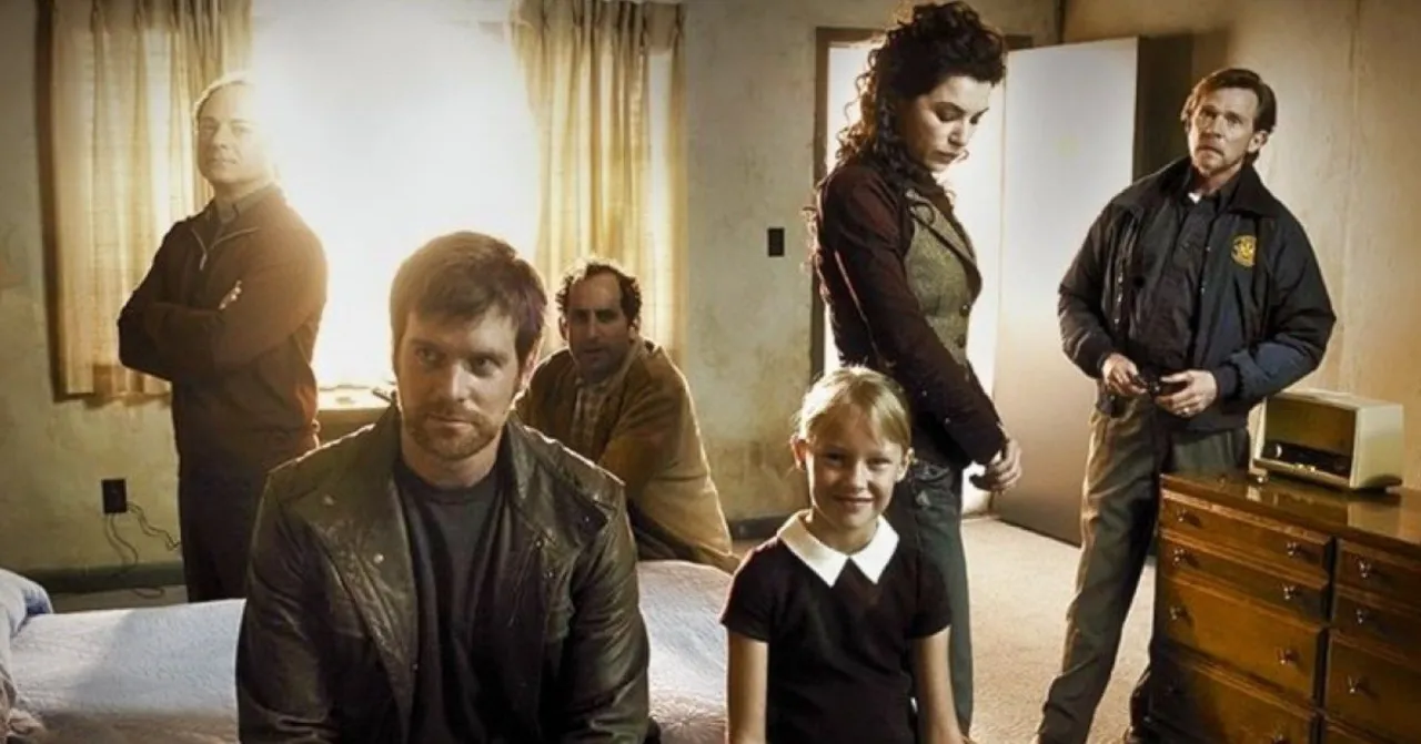 Un grupo de personas, incluyendo una niña, en una habitación. La escena evoca thrillers psicológicos que transcurren en una sola habitación, con miradas tensas y un ambiente de misterio.